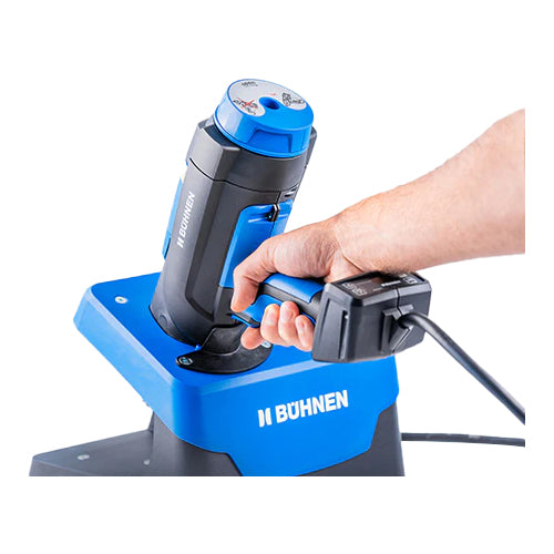 Operator placing Buehnen HB 720 pneumatic glue gun into tool stand for safe upright storage and air service connection