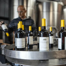 Meler V-Label applicator used for wrap-around labeling on wine bottles in production line