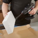 Operator using a Power Adhesives 6300 glue gun to spray hot melt adhesive onto a foam packaging insert.
