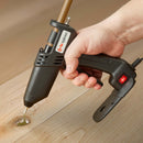 In a close-up woodworking application, a Tec 305 hot melt applicator fills a wood knot with adhesive, demonstrating precise control by Power Adhesives