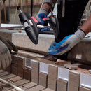 During a construction task, the Tec 3500 glue gun dispenses adhesive along stacked masonry materials.