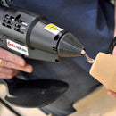 A controlled bead of hot melt adhesive exits the precision nozzle of the Power Adhesives Tec 6100 during material bonding.