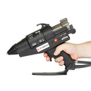 An in-hand view of the Tec 6100 glue gun demonstrates operator grip, trigger reach, and overall scale of the pneumatic applicator.