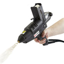 A Tec 7300 pneumatic hot melt spray gun applies adhesive mid-air, showing spray output while operated by hand.