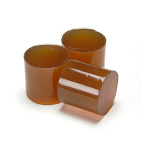 Dark amber 43mm cylindrical glue slugs pictured from the Tecbond 7784 series
